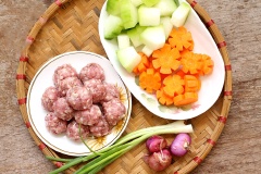 Cà rốt, bí đao gọt vỏ rửa sạch cắt khúc vừa ăn. Thịt băm ướp cùng 1/4 muỗng cà phê muối, hành tím băm nhỏ và 1/4 muỗng cà phê tiêu. Sau đó vo thịt thành từng viên tròn nhỏ.