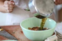 Đun sôi bơ lạt trong nồi rồi tắt lửa, cho các loại lá thơm (lá hương thảo, lá xô) và ớt bột, siro đường, muối vào, trộn đều. Khi hạt đã sẵn sàng, bạn rưới hỗn hợp bơ này vào tô hạt rồi trộn lại.