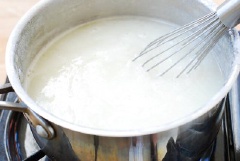 Trong lúc chờ củ cải, bạn hãy cho nước và bột vào 1 cái nồi nhỏ, khuấy đều cho tan bột rồi bật bếp lên đun sôi. Sau đó, vặn nhỏ lửa và nêm thêm đường, nước mắm và muối vào. Nhớ là khi đun hỗn hợp bột này phải đảo liên tục để bột không bị bén.
