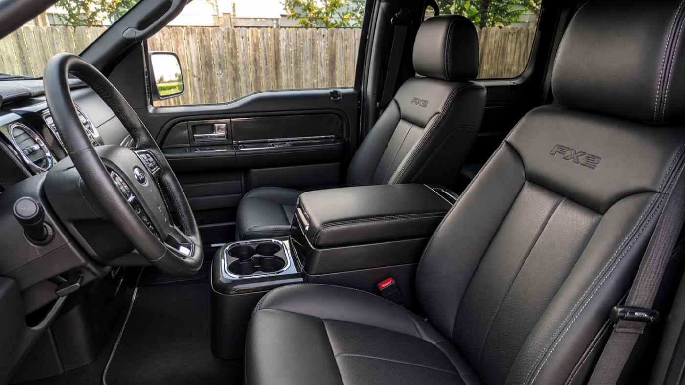 Clean black F-150 FX2 interior with fitted seat covers, showing a sharper cab upgrade for a worn Gen XII truck.