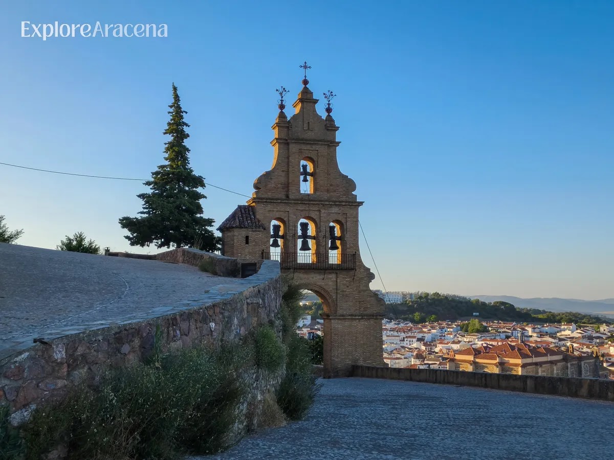 View through the entrance archway of Castillo de Aracena at sunset, overlooking the town below.