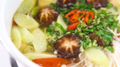 Nước canh sôi lên thì cho đậu hủ, đậu bắp, bạc hà, nấm kim châm vào, chờ nước sôi lại thì rắc ngò gai, ngò om và ớt sừng vào, tắt bếp.