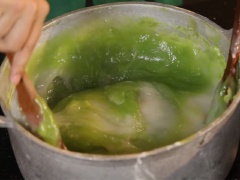 Khuấy đều cho đến khi thấy hỗn hợp bột trong, có bọt khí là bột chín. Nhanh tay chia đều 1 muỗng cà phê nước tro tàu vào hai nồi bột, khuấy nhanh tay. Đổ 2 hỗn hợp lại với nhau, trộn đều tay để tạo gân cho bánh đúc. Phết dầu ăn đều khắp khuôn, đổ bánh đúc gân ra, dàn đều khắp khuôn.