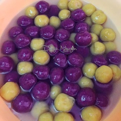 Đổ 100g bột năng vào phần khoai lang tím trộn đều. Nhào thật kỹ để được khối bột khoai mịn. Thực hiện tương tự với phần khoai lang ruột vàng, cho phần khoai hấp chín, rây mịn trộn cùng 100g bột năng và nhào kỹ. Chia bột khoai thành từng phần nhỏ, viên thành từng viên khoai tròn nhỏ. Đun 1 nồi nước sôi, thả lần lượt các viên khoai vào luộc. Chuẩn bị sẵn 1 âu nước lọc, khi nước trong nồi sôi phần khoai dẻo nổi lên trên mặt nước thì dùng muôi thủng vớt ra, thả vào nước đá cho khoai không dính.