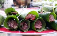 Trải lá lốt lên đĩa, múc lượng thịt vừa đặt vào giữa lá sau đó cuộn tròn lại như têm trầu. Làm lần lượt đến khi hết chỗ thịt. Phết 1 lớp dầu ăn mỏng ra ngoài vỏ miếng chả sau đó xếp vào kẹp chả nướng trên bếp than hoa. Khi nướng chú ý trở đều tay để không bị cháy.