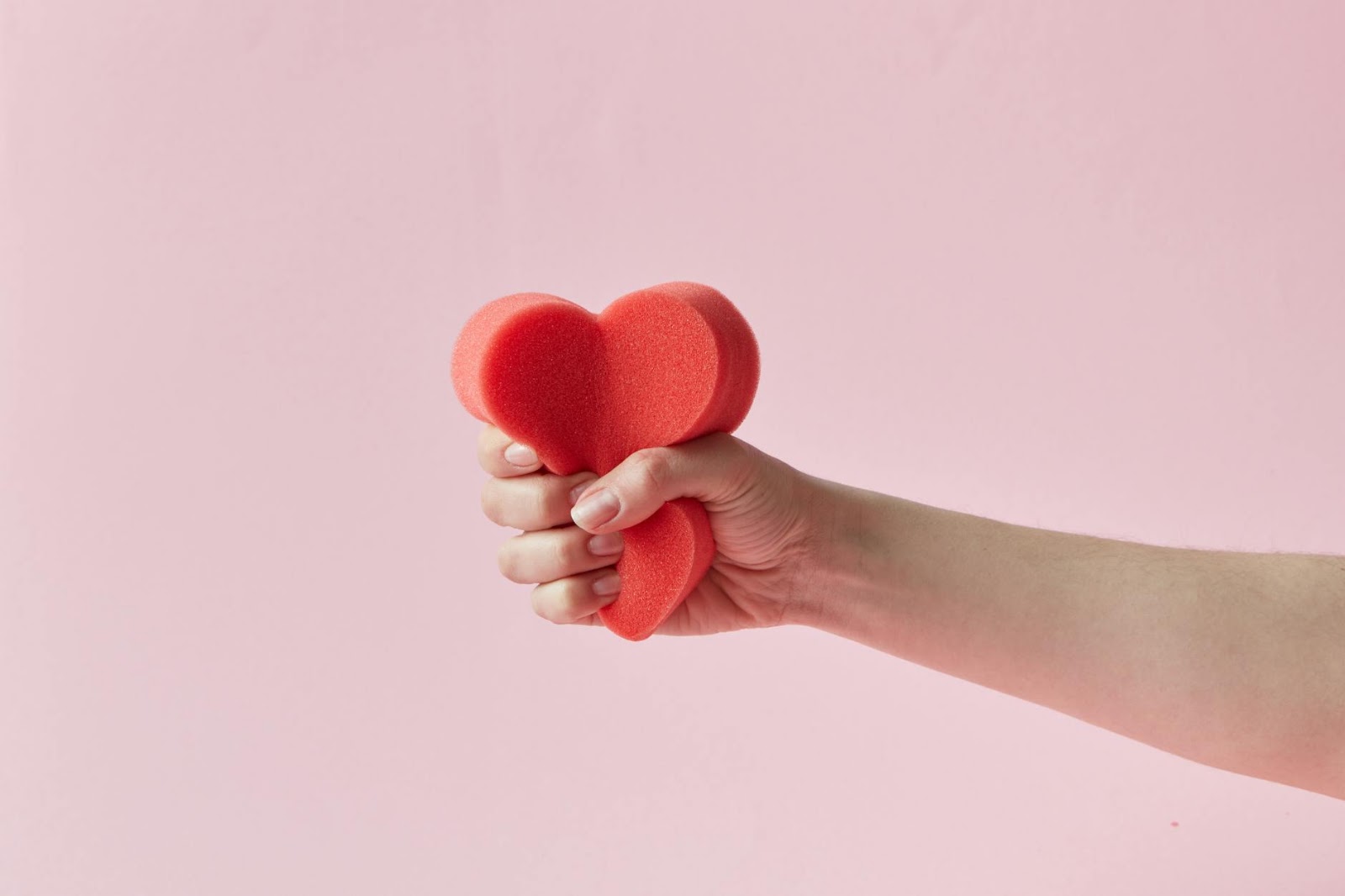 Conceptual image of a robot hand intricately holding a human heart with wires, symbolizing the complex relationship between AI dating apps and genuine emotion.