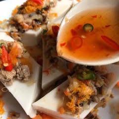 Cho bánh ra đĩa, thêm phần nhân, tôm khô lên. Bánh mềm, mịn ăn rất mềm. Chan kèm nước mắm lên thì ngon không tả.
