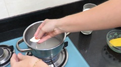 Khi nước sôi thì cho 250g đường vào, đun cho tan hết. Thoa ít bơ lên 1 vòng trong thành nồi để sữa không bị trào khỏi nồi khi đun.