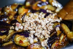 Trong chảo xào thịt, phi thơm tỏi và gừng cắt lát với 1 muỗng canh dầu ăn, trút cà và thịt vào đảo đều tay. Nêm 2 muỗng cà phê hạt nêm, đảo đều khoảng 2-3 phút thì rắc thêm hánh lá cắt nhỏ, trộn đều rồi tắt bếp.