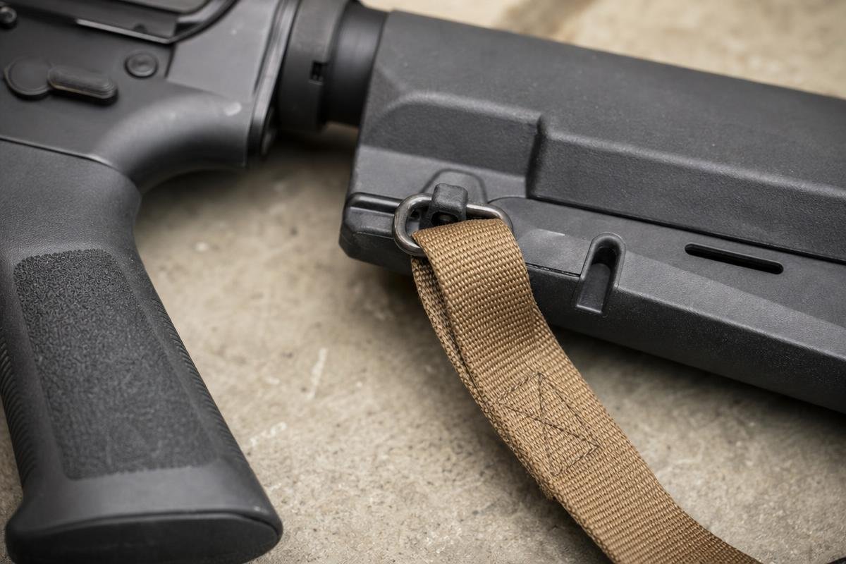 AR-15 sling webbing threaded through a swivel and tri-glide