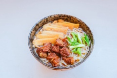 Bún trụng qua nước sôi (Bạn có thể dùng mì khô nhé). Cho bún ra tô, thêm bò hầm nấm lên trên cùng một ít hành lá thái nhỏ là có thể thưởng thức được rồi.