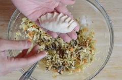 Tiếp theo, múc khoảng 1 muỗng canh rau nhồi vào giữa mỗi tấm vỏ hoành thánh rồi gấp đôi lại, niêm phong các cạnh. Sau đó uốn các cạnh như hình. Lặp lại quá trình cho đến hết nguyên liệu.
