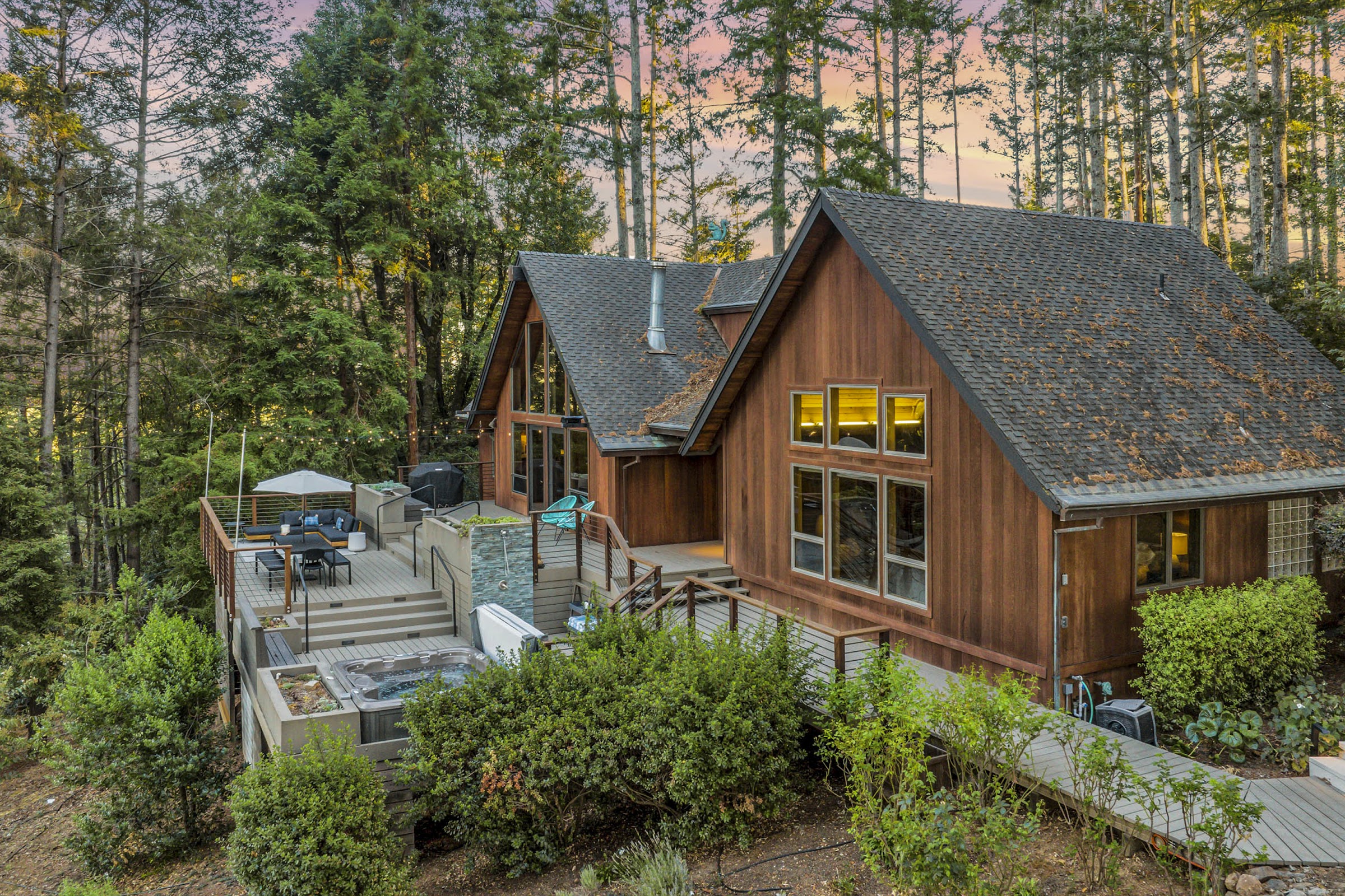 Casa de Lucca pool and fire pit at twilight among the redwoods
