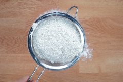 Rây mịn hỗn hợp bột gồm 380gr bột mì ra một mặt phẳng sạch. Dùng tay vun hỗn hợp bột thành hình quả núi. Dùng tay tạo thành 3 hỗ lõm trên bề mặt khối bột. 1 hố lõm cho vào 5gr muối, 1 hố lõm cho vào 60gr đường trắng và 1 hố lõm còn lại cho vào 5gr men nở khô. Dùng tay trộn đều hỗn hợp trên lại cho các nguyên liệu tan đều vào nhau. Tiếp tục tạo thành hình núi với 1 hố lõm ở chóp.