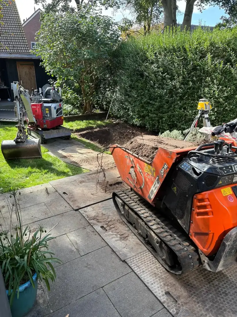 Rupsdumper rijdt grond weg over rijplaten