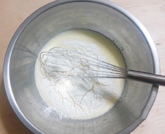 Cho 4 quả trứng gà, 90g đường vào tô to dùng máy đánh trứng đánh sơ qua cho trứng chuyển màu nhạt 1 chút thì dừng lại, thêm 1 muỗng canh mật ong, 100ml sữa tươi, 1 muỗng canh dầu ăn khuấy đều bằng phới lồng cho đều. Cho 280g bột mì, 11g bột nở, 1g bột vani vào tô trứng vừa đánh rồi khuấy đều cho đến khi không còn nhìn thấy bột khô là được, để bột nghỉ 10 phút.