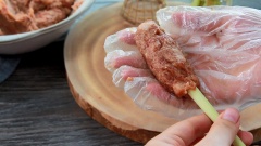 Đeo bao tay vào trộn thật đều tất cả hỗn hợp, rồi dùng màng bọc thực phẩm bọc lại. Để vào ngăn đá 1 tiếng cho thịt ngấm gia vị và giúp nem thêm dai. Sau khi thịt đông dẻo, bạn nắn lấy 1 viên thịt và cuộn vào phần đầu của cây sả. Nhớ nắn chặt tay để nem bò nướng sả không bị rời rạc rơi khỏi cây. Làm tương tự lần lượt cho đến khi hết thịt và đem nem đi nướng trên bếp lửa than nhé.