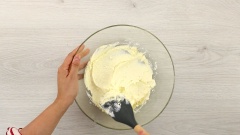 Cho vào tô thuỷ tinh 250gr cream cheese, dùng phới dẹt dằm mịn, sau đó cho vào 50gr đường, dùng phới lồng trộn đều. Cho phần nước cam vào hỗn hợp, trộn đều bằng phới lần nữa. Tiếp tục cho vào tô 150gr whipping cream, 3 giọt màu vàng thực phẩm, trộn đều bằng phới lần nữa đến khi hỗn hợp hoà quyện.
