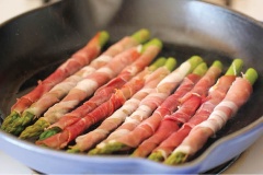 Măng tây rửa sạch, bỏ bớt phần cuống cứng và xơ. Cho măng tây vào nồi luộc sơ. Dùng thịt xông khói cuộn quanh măng tây. Làm nóng chảo với dầu olive, sau đó cho thịt vào chiên đến khi thịt chuyển màu hơi vàng thì đổi mặt cho chín đều.