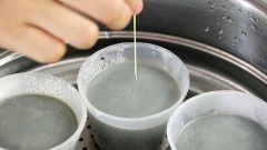 Làm phần flan phủ bên ngoài: Cho 50ml hỗn hợp sữa mè ở trên trộn cùng 1/2 tbs mè đen và mè trắng. Cho hỗn hợp flan phủ vào khuôn rồi cho vào nồi hấp 5 phút cho phần flan phủ hơi đông lại. Kế tiếp đổ hỗn hợp flan trứng mè vào khuôn, hấp lửa nhỏ 25 phút đến khi flan chín.