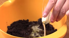 Chia bánh oreo thành 3 phần bằng nhau. Lấy 1 phần trộn với 15gr bơ tan chảy. Sau đó, đổ hỗn hợp bánh oreo vào khuôn bánh.