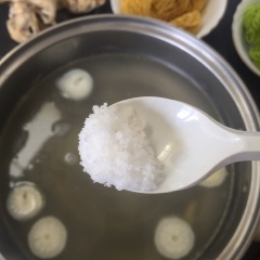 Vớt nấm và bắp ra nêm nếm vào nước lẩu muối hạt nêm cho vừa ăn. Thêm củ hành tím bào mỏng lên mặt.