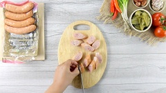 Xúc xích cắt lát xéo, đem ướp với 1 muỗng canh ớt sa tế, 1 muỗng cà phê đường và 1/2 muỗng cà phê tiêu.
