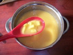 Gelatine tan hết đổ sữa đặc cùng phần xoài xay vào nồi, khuấy tan. Cuối cùng khi nước chỉ còn hơi âm ấm cho các miếng xoài vào trộn lẫn.