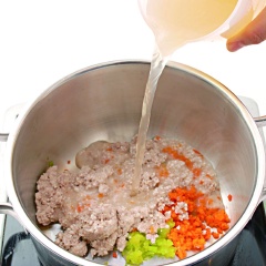 Cho gạo và thịt bò vừa giã vào nồi cùng với bí ngòi và cà rốt. Đổ 750ml nước dùng gà, đun sôi rồi hạ nhỏ lửa, đun liu riu cho cháo chín nhừ. Nêm ít muối và hạt nêm cho vừa miệng, tắt bếp.