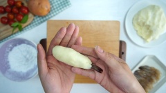 Cách làm tôm cuộn khoai tây: Vo bột khoai tây thành những cục tròn nhỏ khoảng 20gr rồi dàn mỏng ra và cuốn tôm đã ướp vào giữa, dùng tay miết để khoai nghiền ôm sát tôm, chỉ chừa lại phần đuôi để khi chiên xòe ra đẹp. Sợi khoai tây sau khi ngâm nước muối lấy ra để ráo, thấm khô và lấy khoảng 50gr bột bắp rắc đều lên từ từ để sợi khoai được áo bột và có độ kết dính. Sau đó dùng từng sợi khoai cuốn vào phần tôm vừa bọc bằng khoai nghiền.