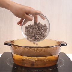 Làm trân châu đường đen: Bắc nồi nước sôi lên bếp, cho 100 gr trân châu đen vào nấu sôi, sau đó đậy nắp, đun lửa nhỏ 20 phút. Khi trân châu đã mềm bạn tắt bếp, vẫn đậy nắp và ủ trân châu trong 10 phút. Sau đó lọc trân châu qua rây. Cho phần trân châu đã lọc vào tô, cho vào 60 gr đường đen, trộn đều cho đường tan hoàn toàn, vậy là ta đã có phần trân châu đường đen ngon không kém ngoài hàng rồi.