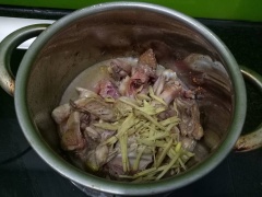 Tiếp theo, cho gừng vào, đảo đều. Nêm gia vị 1 muỗng canh nước mắm, 1 muỗng canh đường trắng cho vừa miệng. Đổ 1/2 chén nước vào, hạ nhỏ lửa, nấu đến khi thịt gà chín mềm, phần nước trong nồi cạn gần hết.