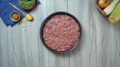 Cho 500gr thịt bò xay trộn cùng 100gr giò sống và 50gr mỡ heo, ướp gia vị với 1 muỗng canh tỏi băm, 1 muỗng canh hạt nêm, 1 muỗng canh đường, 2 muỗng canh nước mắm, 1 muỗng canh tiêu, 1 muỗng cà phê dầu ăn. Cho 50gr bột bắp, 10gr bột nở vào 100ml nước lạnh, khuấy đều rồi cho vào hỗn hớp thịt vừa ướp. Nhồi đều tay cho gia vị hòa quyện rồi cho thịt vào túi zip hoặc khay to rồi dàn mỏng thịt, sau đó cho vào tủ đông để khoảng 3-4 tiếng.
