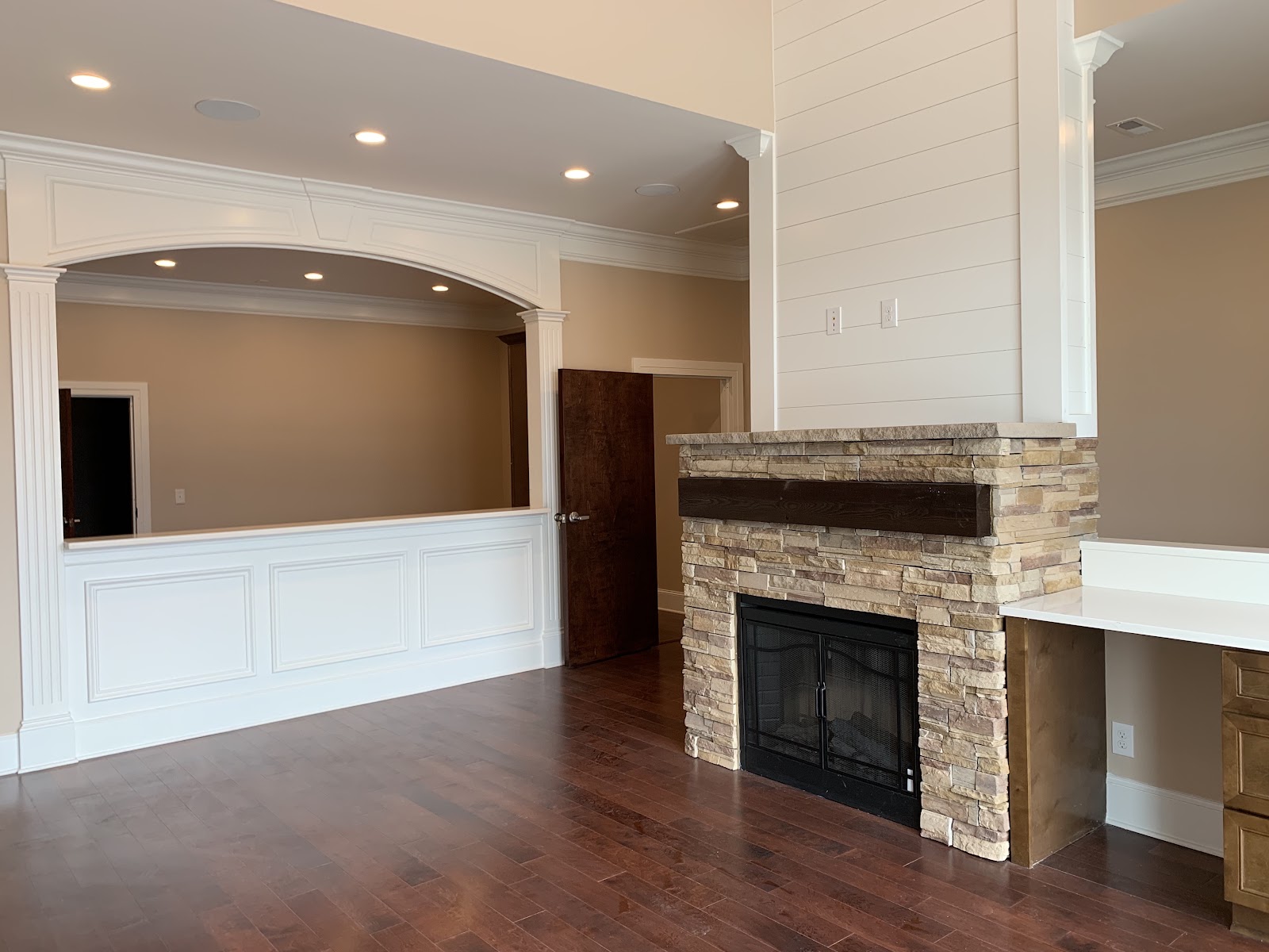 Interior of a health clinic showing a stacked stone fireplace, hardwood floors, and a white paneled counter area with an arched opening.