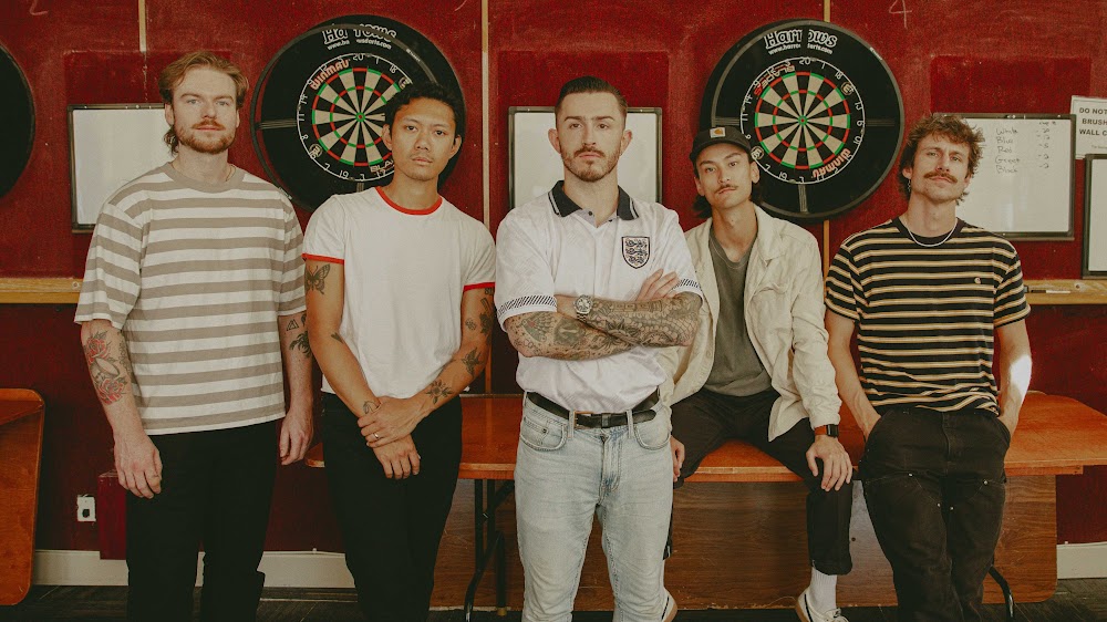 The five members of Chief State stand side by side in front of dartboards