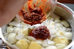 Khoai tây gọt vỏ, rửa sạch, cắt miếng vừa ăn. Bí ngòi rửa sạch, cắt lát mỏng vừa. Hánh tây cắt múi cau. Cho tương ớt Hàn Quốc, ớt bột, nước tương, tỏi băm và nước mắm vào tô nhỏ, trộn đều. Tiếp đó, cho khoai tây, hành tây vào nồi, chế nước vào sau đó cho phần nước sốt đã làm vào khuấy đều, đem nấu trên lửa lớn đến khi khoai chín mềm thì cho bí ngòi vào tiếp tục nấu khoảng 2 phút. Nêm nếm lại cho vừa ăn.