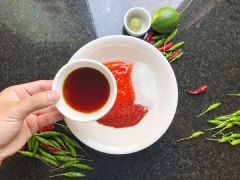 Cho hỗn hợp nước mắm, đường trắng, tương ớt, nước cốt chanh, chanh thái lát mỏng nhỏ còn giữ vỏ, ớt bột Hàn Quốc, ớt hiểm xanh thái đôi.