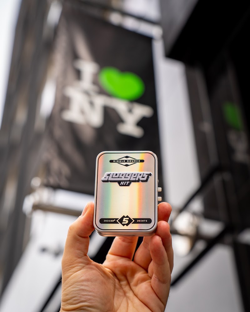 Cannabis brand tin held outside New York dispensary — cannabis brand photography