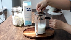Tạo bọt sữa: Hâm nóng 180ml sữa tươi thanh trùng Dalat Milk rồi đổ vào bình French Fress. Gắn piston vào và ấn kéo liên tục trong khoảng 15 - 20 giây để tạo bọt sữa. Sau đó, đổ sữa vào ly cà phê, thêm bọt sữa, bột cacao lên mặt ly và tạo hình tùy thích.