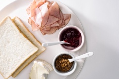Chuẩn bị nguyên liệu. Phết mứt cherry và mù tạt lên bánh mì, xếp các lớp phô mai và thịt nguội lên, cuối cùng đậy bánh lại, cắt đôi bánh ra. Bắc chảo lên bếp, láng một lớp bơ đều quanh chảo, cho bánh mì lên áp chảo đều 2 mặt cho đến khi phô mai tan chảy.