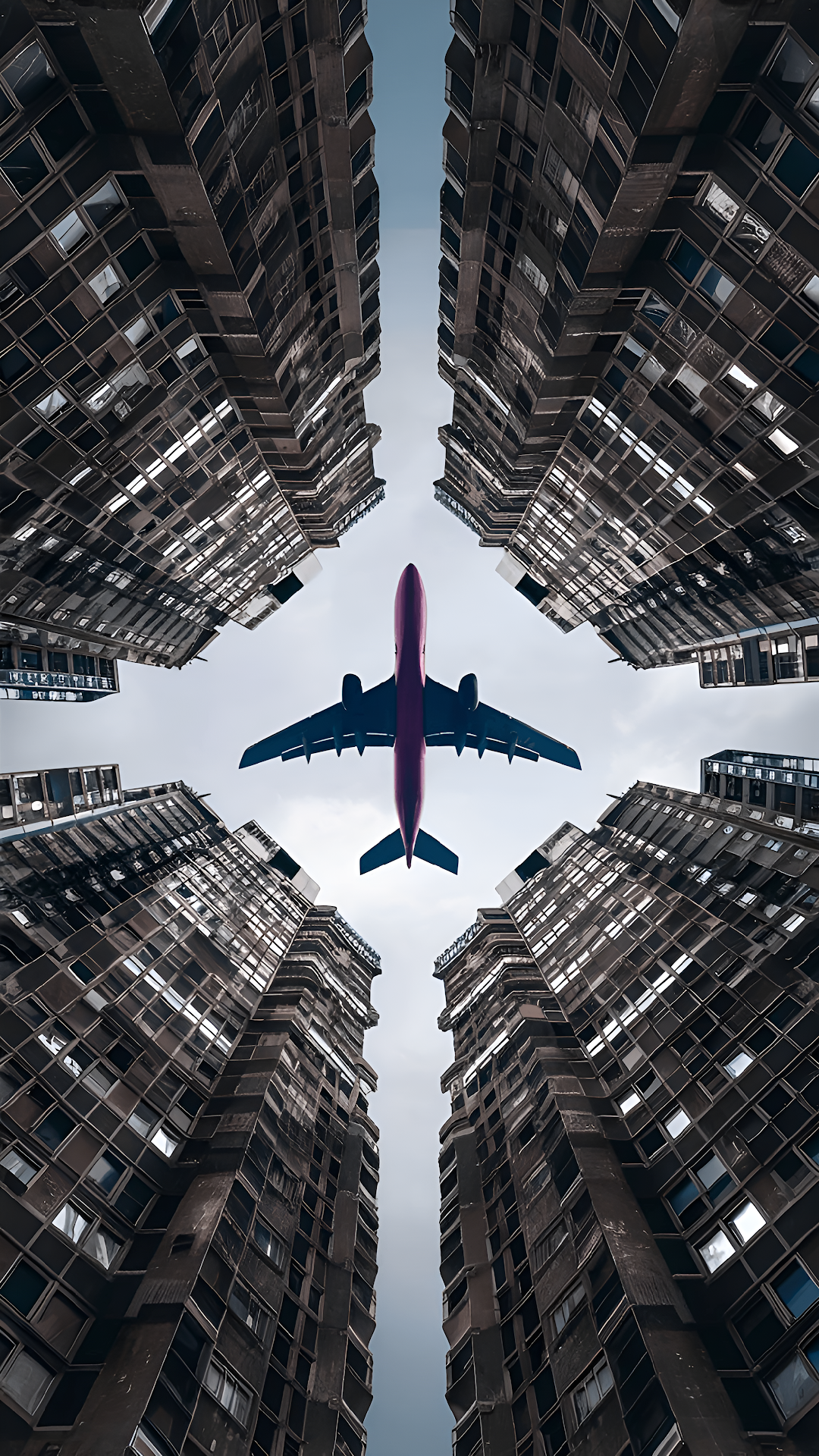 Airplane Flying Between Towering Skyscrapers from Below - Free 4K mobile Wallpaper