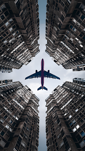 Airplane Flying Between Towering Skyscrapers from Below