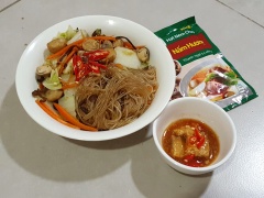 Tiếp tục cho thêm phần nấm đã xào vào trộn đều với rau và miến. Cho thêm một ít tiêu và ớt thái lát cho thơm ngon hơn. Trình bày thức ăn ra đĩa và ăn kèm với chao hoặc nước tương ớt.