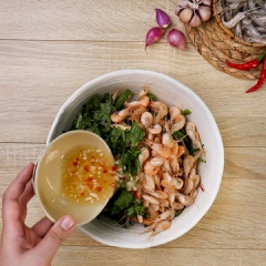Cho rau muống đã vắt khô vào tô lớn, thêm tép rang chín cùng với 25 gram rau thơm cắt nhuyễn (húng quế và kinh giới) rồi từ từ cho phầm nước trộn nộm vào trộn đều là hoàn thành.
