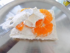 Chuẩn bị một mặt phẳng, đặt lát bánh mì lên dĩa cố dịnh rồi trét một lớp kem mỏng, xếp lên 1 lớp cam, tiếp 1 lớp kem rồi 1 lớp bánh đến kem và trái cây. Cứ làm như vậy mỗi lớp bánh là một loại trái. Lớp cuối cùng là bánh mì và trét đều kem phủ khắp bánh. Còn dư kem, bạn cho vào túi bắt và bắt thành những bông nhỏ trên bánh, trang trí thêm trái cây.