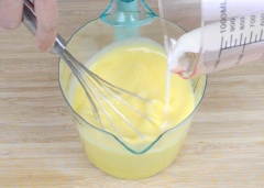 Cho trứng gà vào chén. Đổ từ từ 300ml sữa đậu nành, 1/2 muỗng cà phê muối vào, đánh đều.