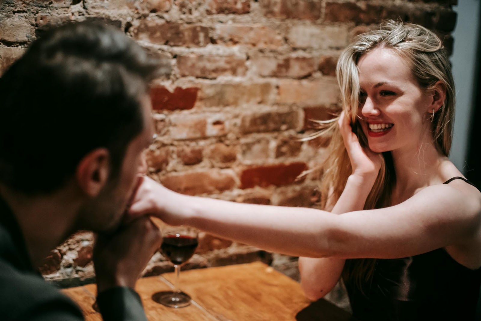 Two individuals genuinely laughing together in a coffee shop, symbolizing authentic human connection beyond AI dating apps.