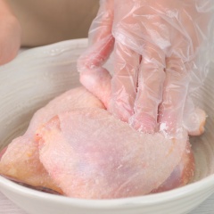 Cho 1 muỗng canh muối vào 700gr đùi gà góc tư Mỹ, chà sát và rửa sạch rồi lột bỏ lớp da gà.