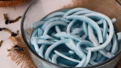 500gr cơm dừa non bạn mua về rửa thật sạch với nước, rồi cắt sợi khoảng 1-2cm rồi đem ngâm cùng nước đậu biếc 2 tiếng cho dừa thấm màu rồi vớt dừa ra. Nước đậu biếc còn dư đem trộn cùng với 50gr sữa đặc cho hòa quyện.
