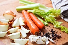 Cho dầu ăn vào nồi lớn, đun to lửa. Khi dầu nóng, cho xương gà vào nồi xào qua cho đến khi gà ngả màu vàng và giòn. Lật mặt và đun tiếp một vài phút. Chuẩn bị các nguyên liệu và gia vị. Cần tây, cà rốt, hành tây, tỏi làm sạch và cắt nhỏ. Cho tất cả nguyên liệu vào nồi gà, đổ nước vào.